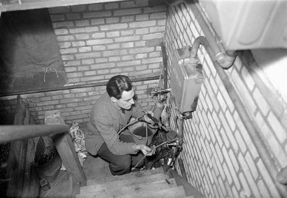 A plumber working on pipework